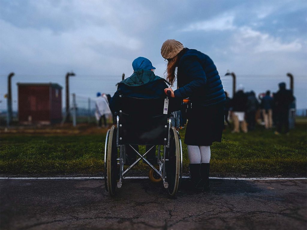 one-person-talking-to-another-person-in-a-wheelchair-outside