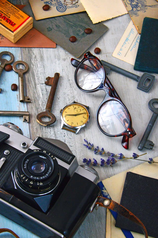 collection of trinkets, camera, watch and glasses